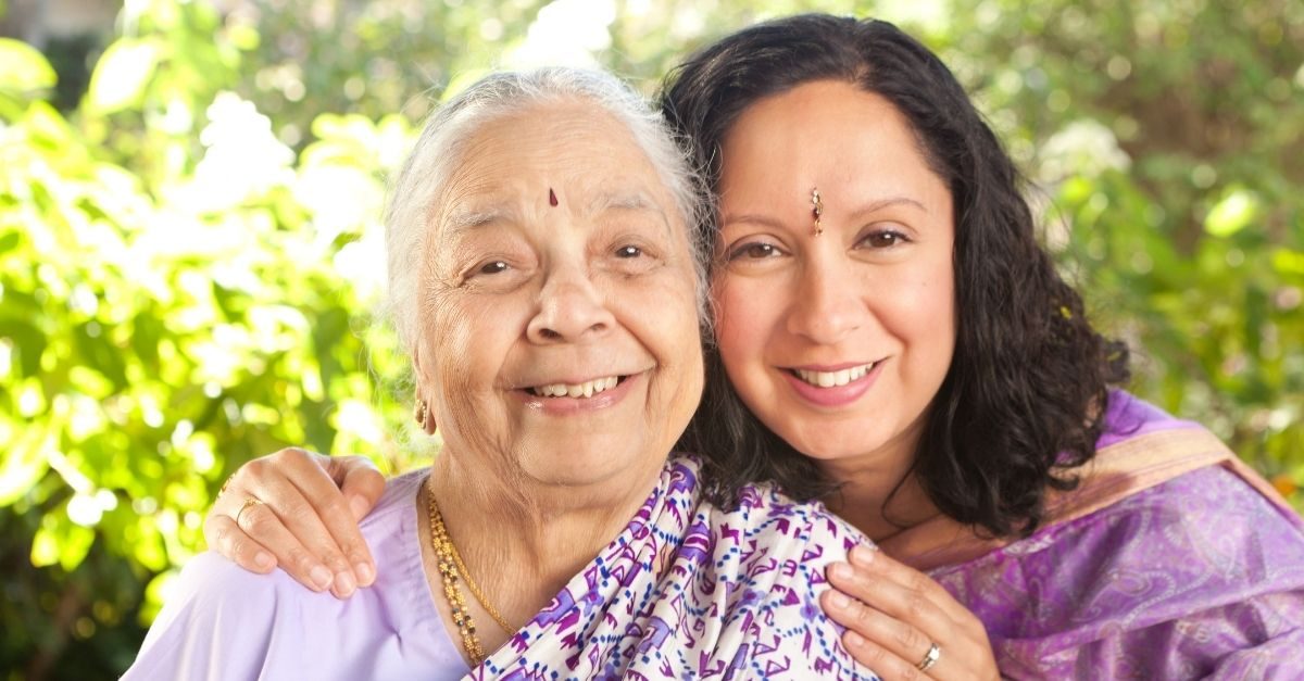 A grandmother and her daughter smiling together